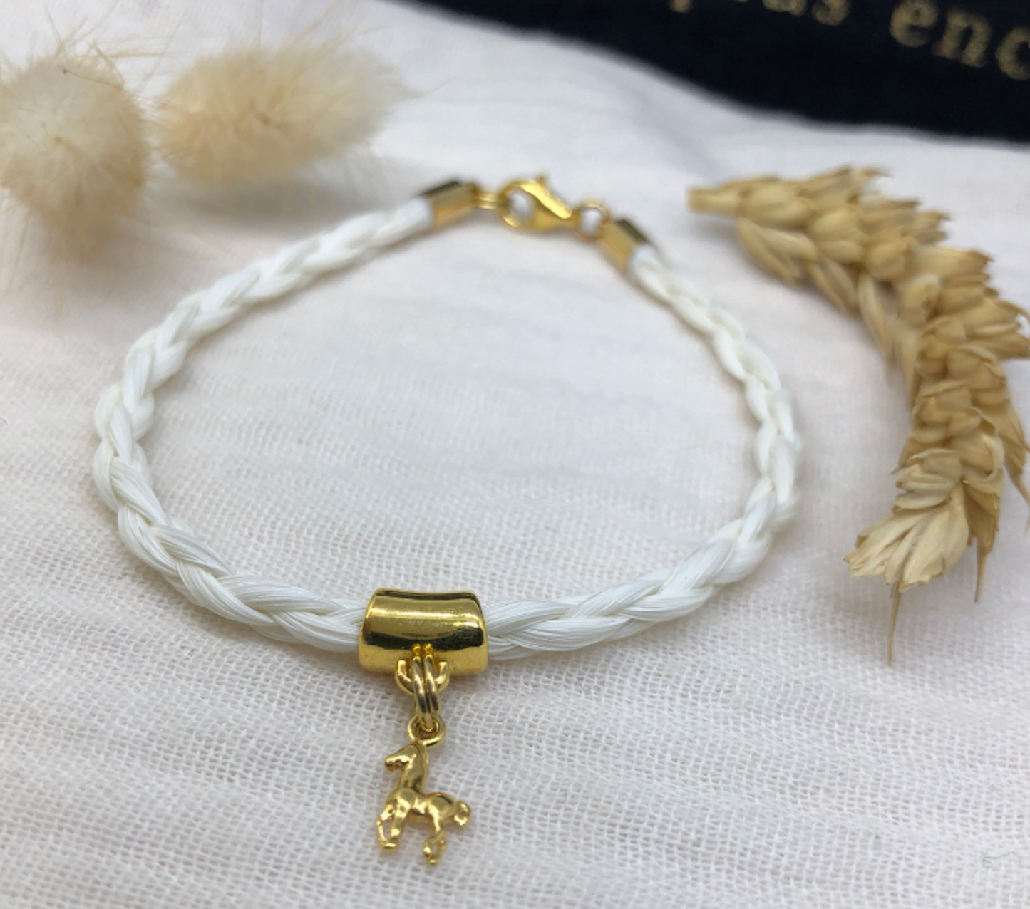 bracelet en crin de cheval avec tresse ronde et breloque cheval en acier inoxydable doré ou argenté.
